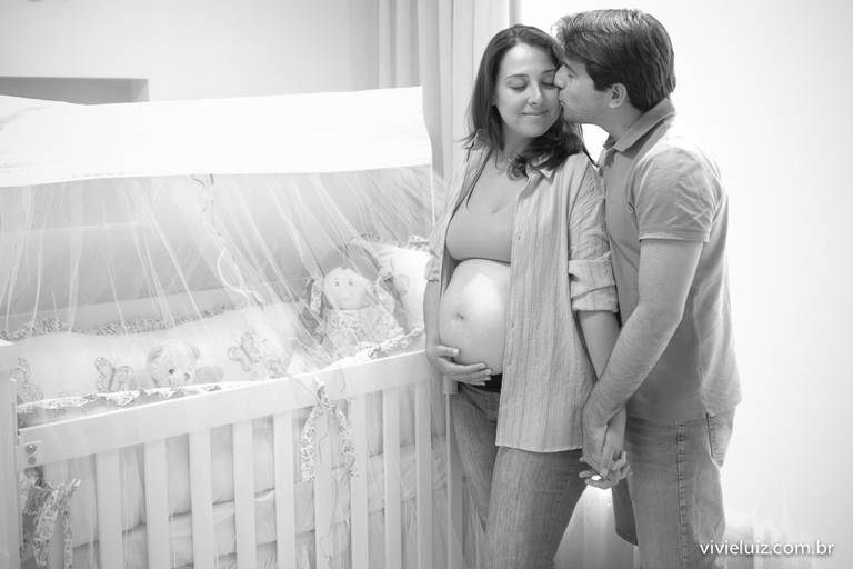 pai e mãe no quarto à esoera da nova filha