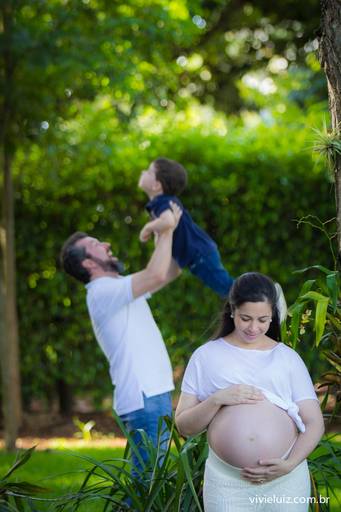 mulher grávida e pai brincando com o filho