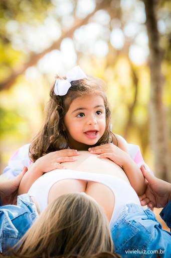 filha em cima da barriga grávida da mãe