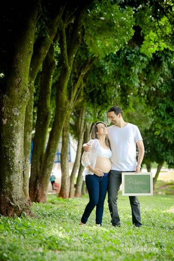 casal segurando o quadro com nome do novo bebê