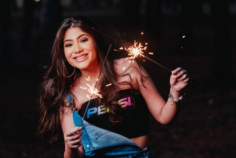 Ensaio da debutante Débora em Brasília DF segurando sparkles em seu ensaio de quinze anos.