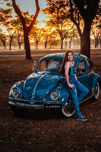 Ensaio de 15 anos em Brasília da debutante Débora no fusca azul durante o pôr do sol. 