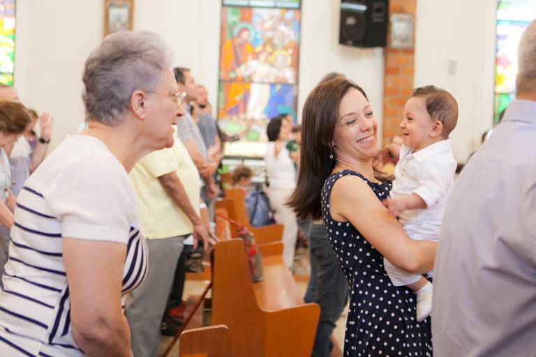 menino no colo da madrinha brincando com a avó durante batismo realizado na Paróquia Verbo Divino, Chácara Santo Antonio, Morumbi, Zona Sul, São Paulo 