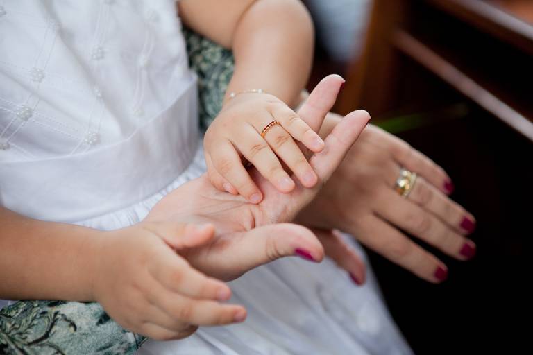mão de bebê sobre a mão da madrinha, batismo com 3 anos, batismo criança grande, batizado realizado Paróquia Nossa Senhora de Fátima da Vila Leopoldina, Zona Oeste, São Paulo