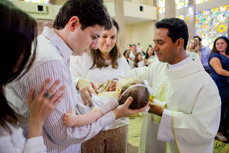 padre passando óleo do crisma em menina durante batizado realizado no Santuário São Judas Tadeu, Jabaquara, Zona Sul, São Paulo
