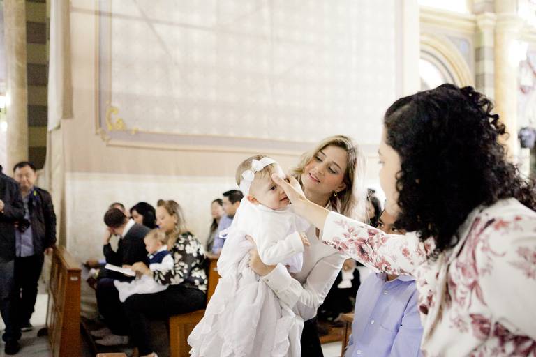 mãe fazendo sinal da cruz na testa de menina durante batizado na Catedral de Santo André, ABC, São paulo 