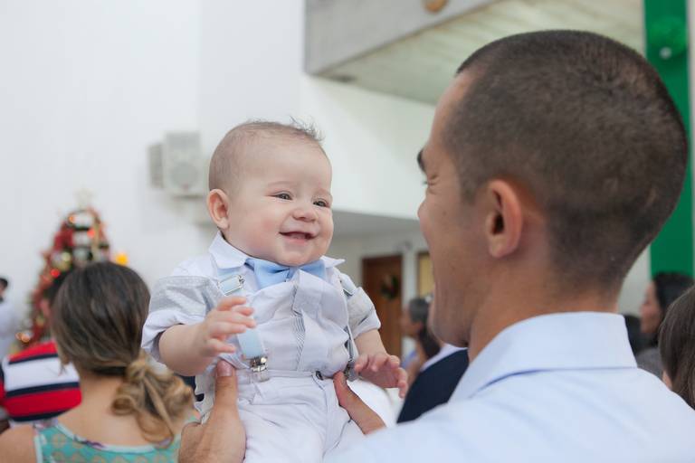 menino rindo para o pai, fotografia espontanea feita durante batizado na Paróquia São José, Osasco, São Paulo