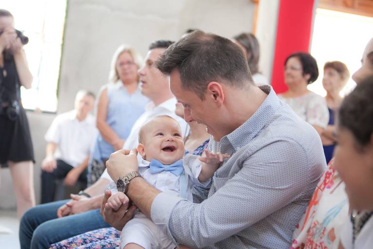 criança brincando com o padrinho durante batizado na Paróquia São José, Osasco, São Paulo