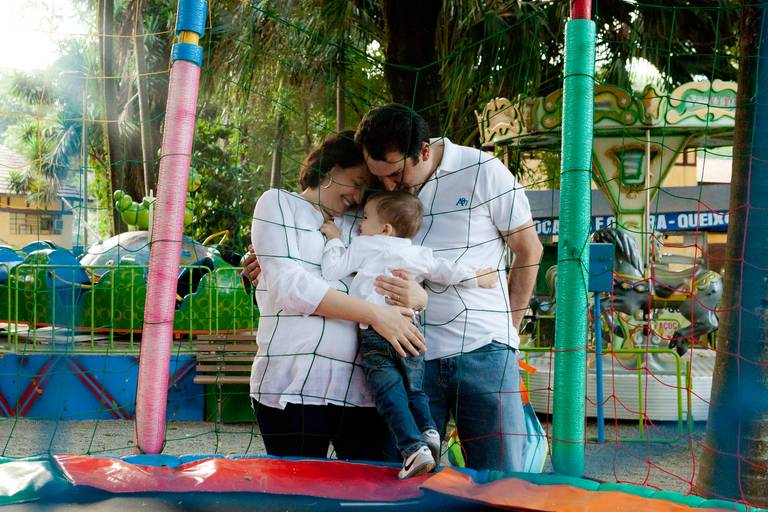 menino abraçando os pais no pula-pula durante ensaio de família no Parque Da Agua Branca, Pompéia, Zona Oeste, São Paulo