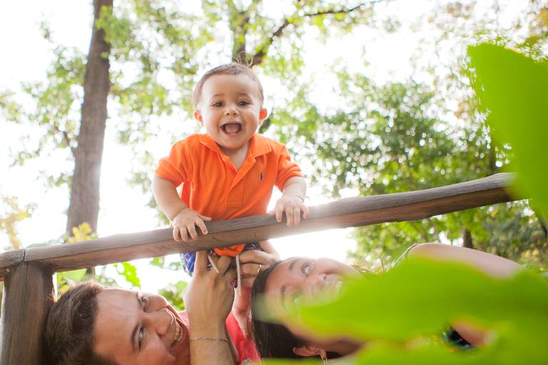 menino brincando com os pais durante ensaio de família no parque em Barueri, Alphaville, São Paulo