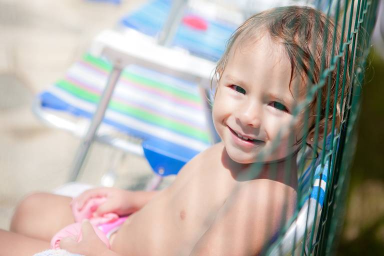 menina sentada na cadeira de praia durante ensaio de família na piscina em Alphaville, Barueri, Santana de Parnaiba, São Paulo