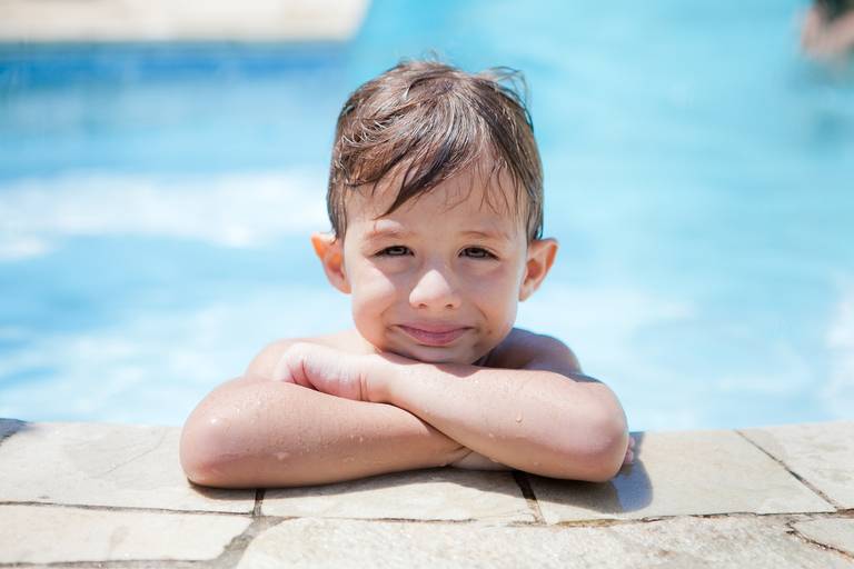 menino fazendo pose durante ensaio de família na piscina em Alphaville, Barueri, Santana de Parnaiba, São Paulo