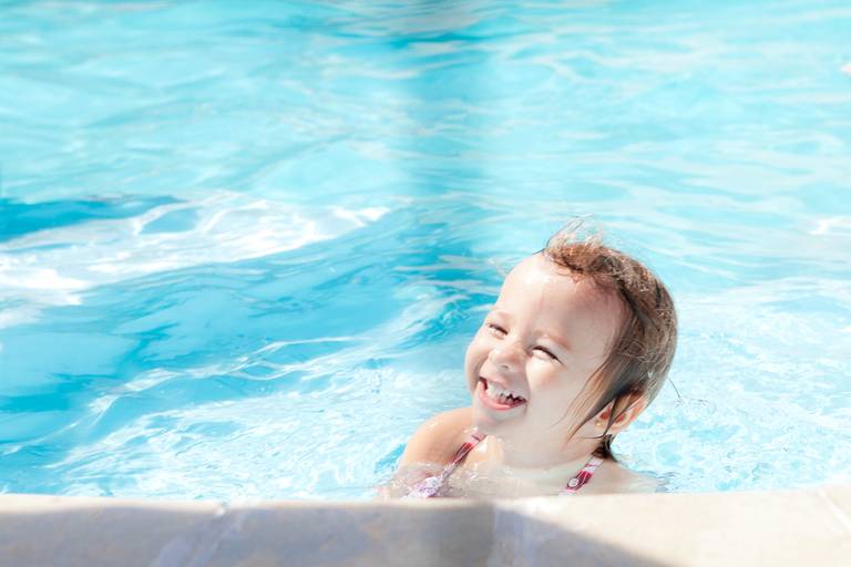 menina rindo durante ensaio de família na piscina em Alphaville, Barueri, Santana de Parnaiba, São Paulo