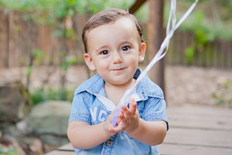 menino batendo palmas durante ensaio de família no parque em Barueri, Alphaville, São Paulo