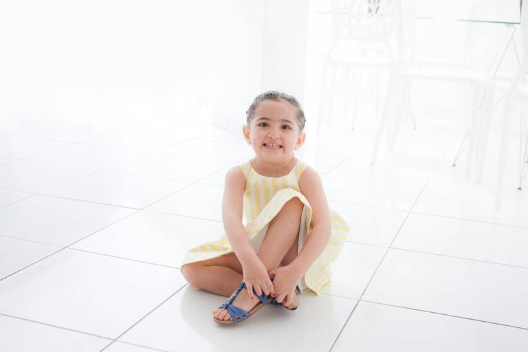 menina de fazendo pose sentada em sua festa de 3 anos no Buffet Spazio Reale em Moema, Zona Sul, São Paulo