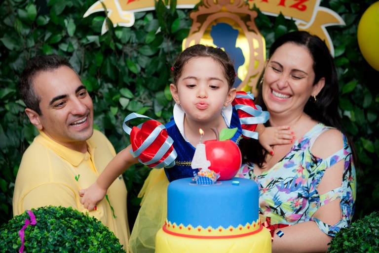  menina no colo dos pais apagando a vela em festa de 3 anos no Buffet Spazio Reale em Moema, Zona Sul, São Paulo