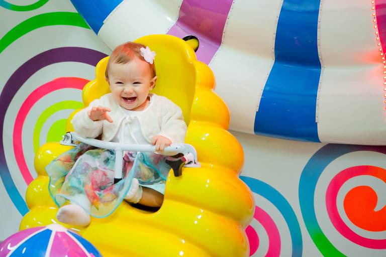 menina sorrindo brincando na roda gigante em sua festa infantil de 1 ano no Buffet EcoKids, São Caetano do Sul, São Paulo