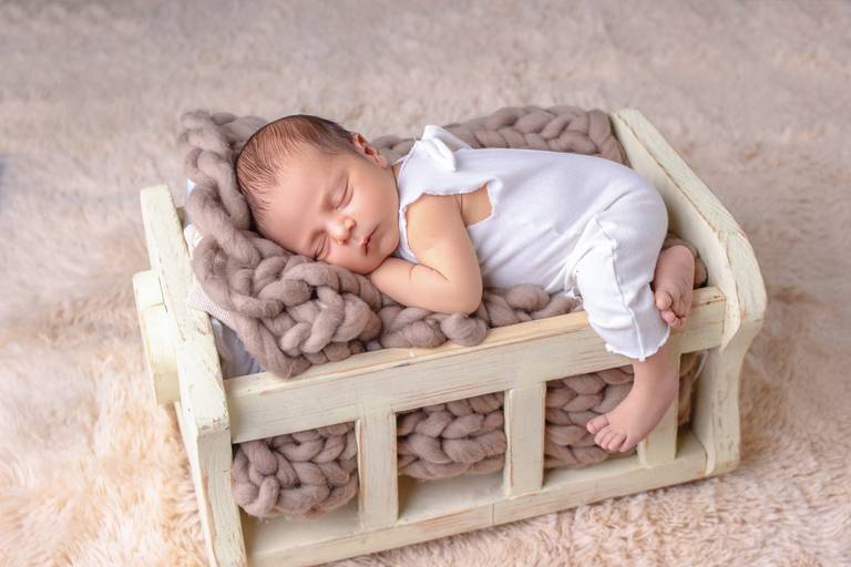 bebê em berçinho de newborn para sessão fotografica em barreiro Belohorizonte