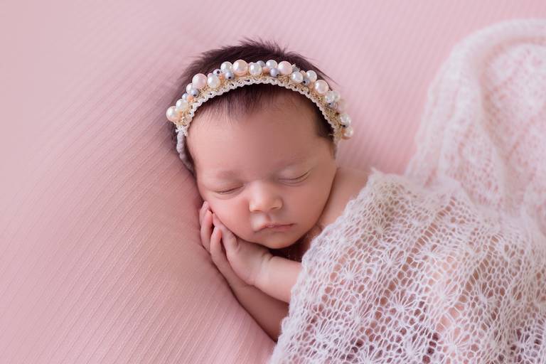 bebê com a mão no rosto