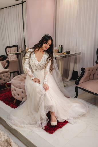 noiva sentada admirando seu vestido