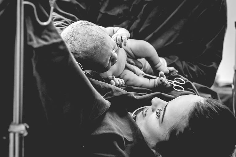 bebê sendo apresentado à mãe logo após o parto