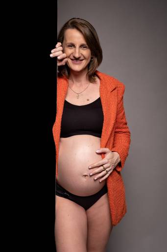 ensaio de gestante em estúdio ela com a mão na barriga 