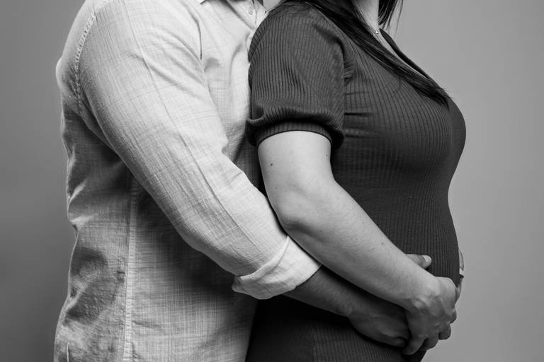 casal com mãos na barriga da gestante
