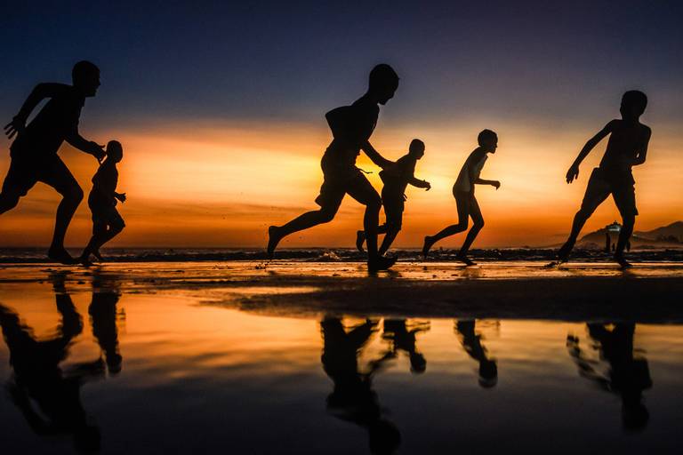Crianças correndo 
Registrada na praia de Itaúna, em Saquarema. Essa fotografia retrata a liberdade de ser criança, os reflexos na água transparecem a diversão e leveza dessa fase da vida.
