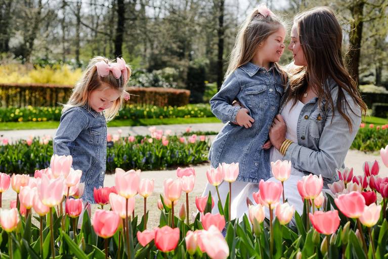 Mother and daughters exploring pink tulip fields during a Keukenhof photoshoot, a popular spring day trip for travelers visiting the Netherlands.