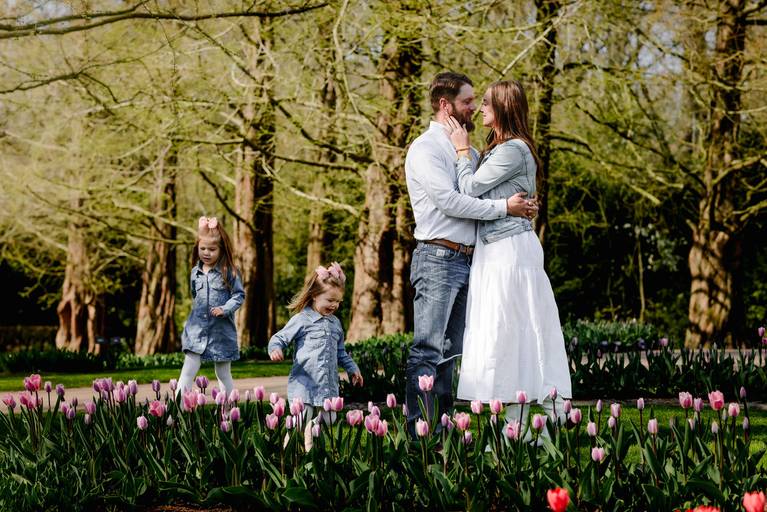 Family sharing a quiet moment surrounded by tulips in Keukenhof, photographed during their Amsterdam vacation.