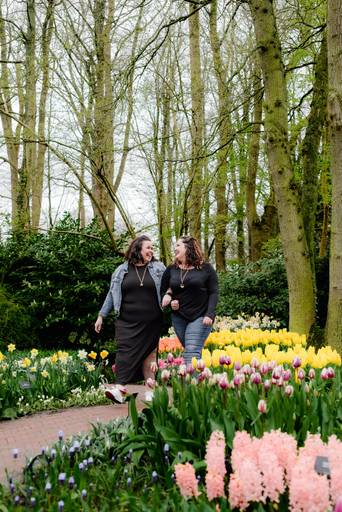 Two sisters walking through Keukenhof Gardens during a spring photo session, a relaxed excursion option for river cruise passengers visiting the Dutch flower region