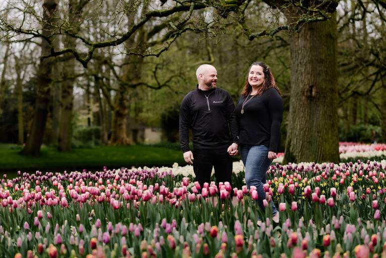 Couple strolling through tulip fields at Keukenhof Gardens during a private photography session, perfect for travel agents planning spring activities for river cruise travelers.