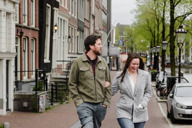 Couple walking through the historic streets of Amsterdam during a guided photo session, a scenic activity for visitors.