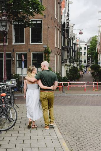 Couple walking arm in arm near the Jordaan area during an Amsterdam photo session.