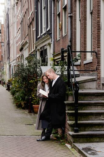 Couple sharing a quiet moment on a charming Amsterdam street, captured during their romantic vacation photoshoot.