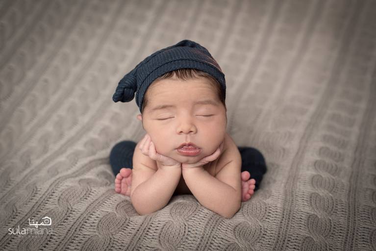 bebê Newborn na pose do sapinho e touca azul