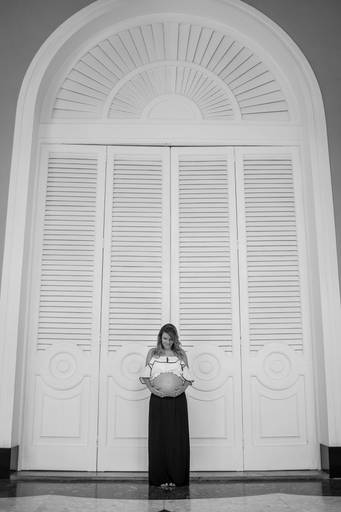 Gestante em frente a porta de madeira branca
