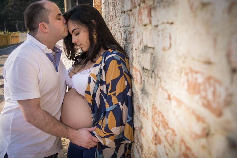 Gestante sendo beijada na testa pelo marido