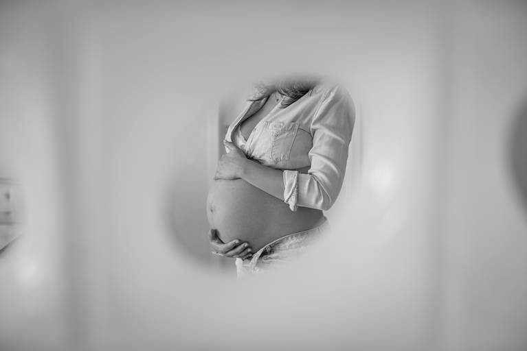 Gestante segurando a barrida dentro de moldura oval