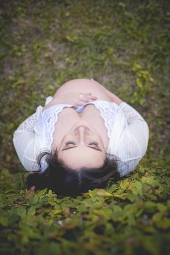 Gestante de branco no meio do verde