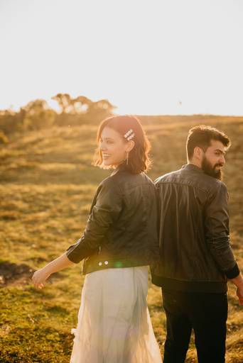 noivos sorrindo em ensaio pré-wedding no pôr do sol. 