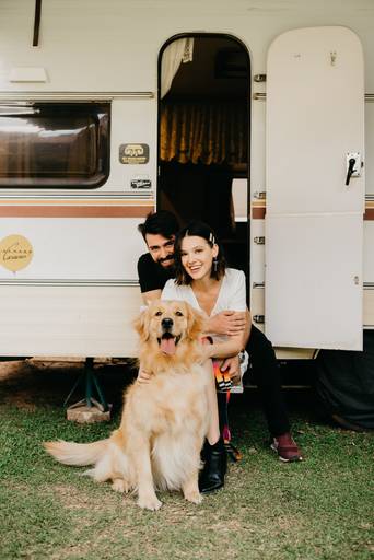 Noivos com golden e um trailer antigo. 
