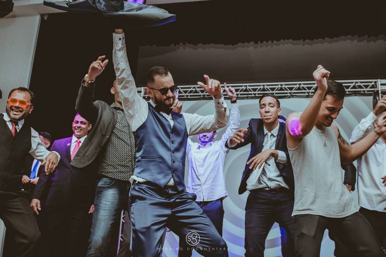 fotografia de noivo dançando no palco do casamento com padrinhos em Guarulhos