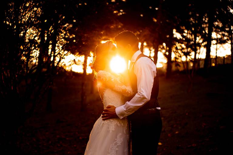 Noivos beijo pôr do sol