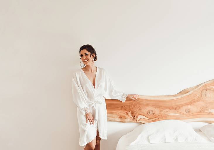 noiva vestir no quarto simples cabeceira da cama em madeira rústica noiva de roupão
