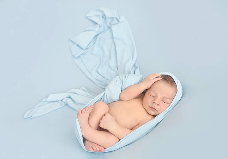 menino newborn laço azul claro a dormir pose relaxado harmonia