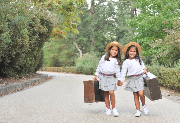 Sessão gemeas roupa igual malas chapeus caminhar no jardim felicidade sameiro