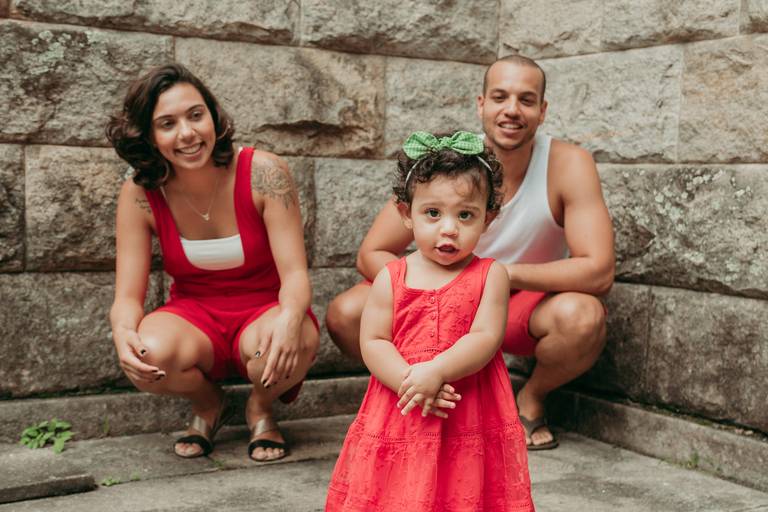 bebê de 1 ano na frente dos pais sorrindo 