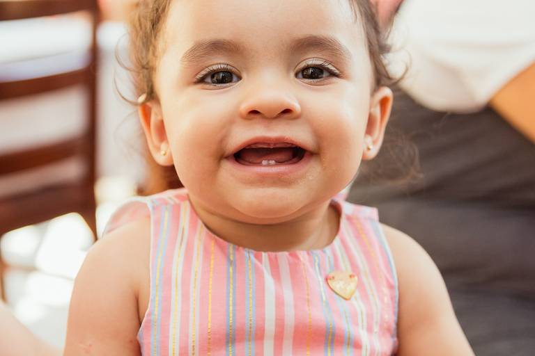 bebê sorrindo durante sua festa de 1 ano das princesas