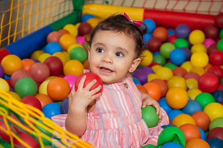 criança na piscina de bolinha durante sua festa de 1 ano das princesas
